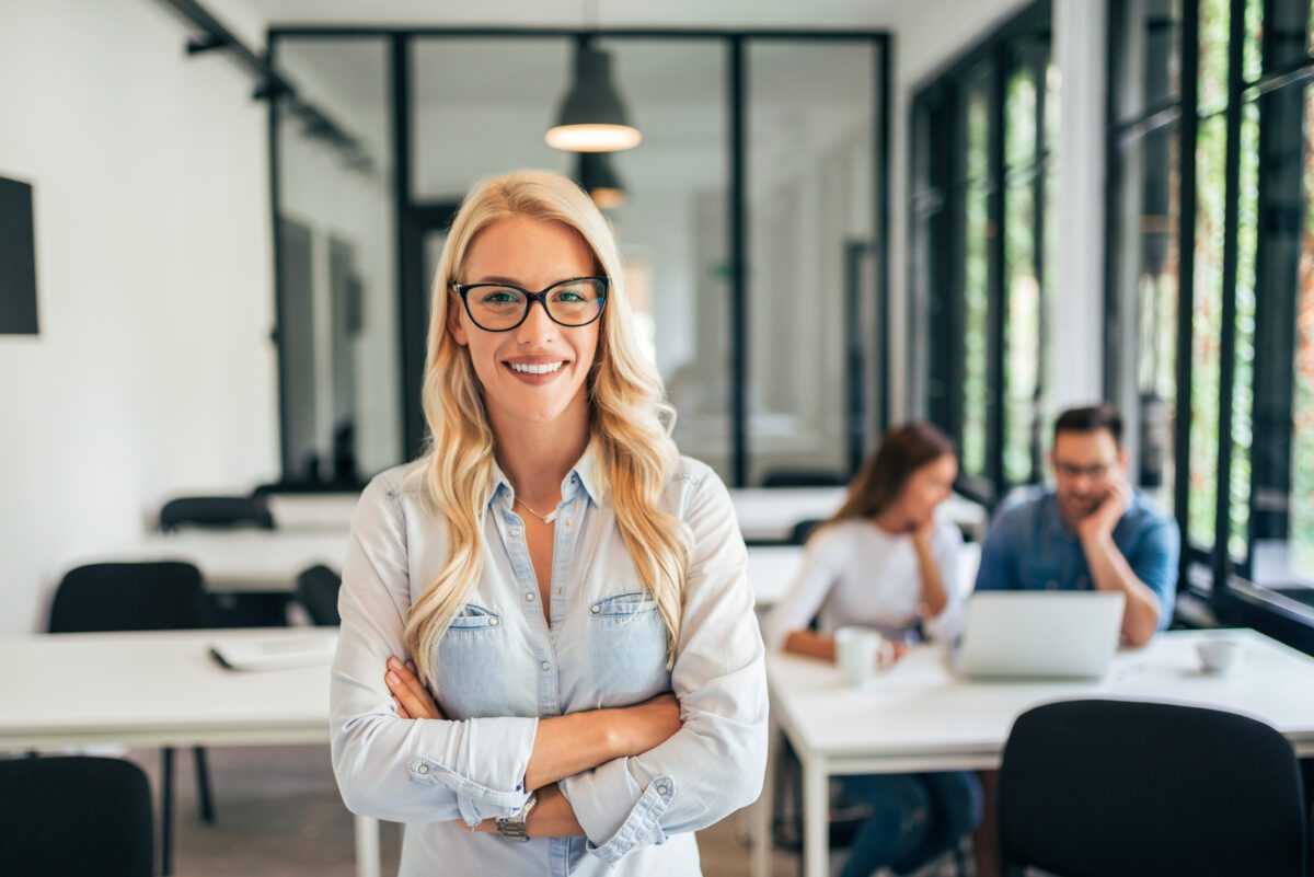 Portrait of casual female leader. Employees in the background. Mitarbeiter Vertriebsinnendienst PROXESS (m/w/d)