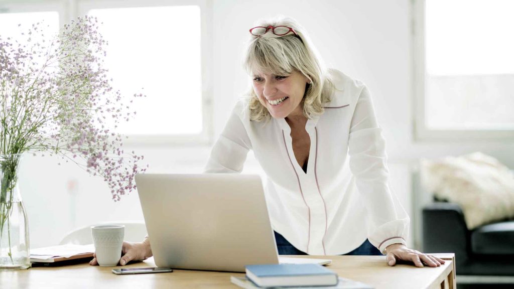 Frau stehend vor Laptop